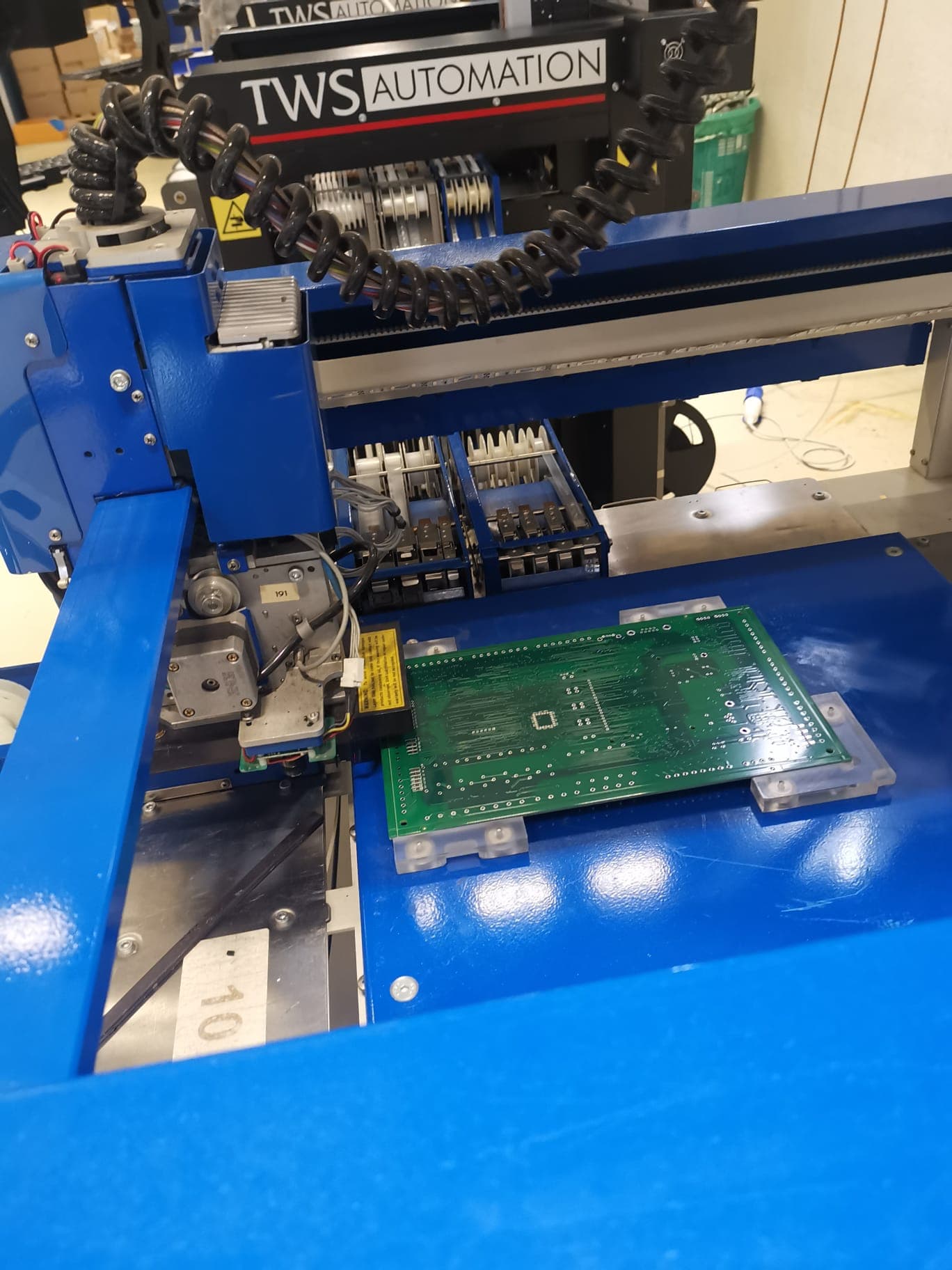 Testa pick-and-place sopra una scheda verde sulla linea di assemblaggio